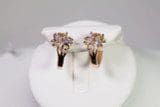 A pair of Floral Design Earrings With Gem Stones displayed on a white stand.