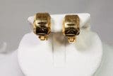 A pair of 14k GP Yellow Gold Earrings on display on a white, padded stand against a neutral background.