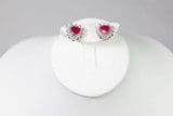 A pair of Pink Gem Stone Earrings 10kGP Hearts Shape displayed on a white stand against a gray background.