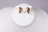 A pair of 10k 4-Color Earrings is displayed on a white circular stand against a neutral background.