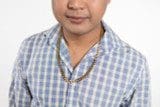 A person wearing a blue checkered shirt and a 14kGP Curb Chain Yellow Gold is seen from the shoulders up against a plain white background.